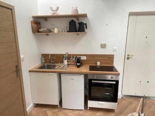 une petite cuisine avec un évier et un comptoir dans l'établissement La Halte des Arènes de Nîmes Nude Beauté du Minimalisme, à Nîmes