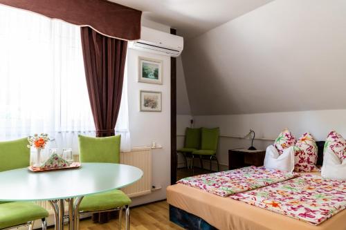 a hotel room with a bed and a table at Magdalena Apartmanház in Keszthely