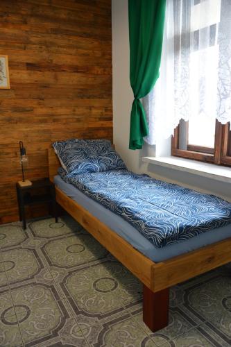 a bed sitting in a room with a window at Magic Wood Guest House in Lidzbark Warmiński