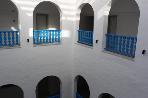 a room with blue and white walls and arches at Hôtel Medina in Sousse