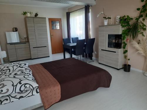 a bedroom with a bed and a table and chairs at Uroczy Zakątek in Krynica Morska