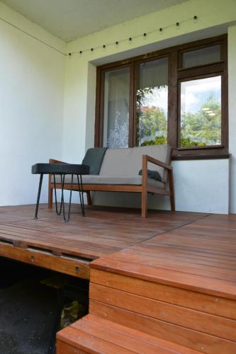 a bed sitting on a wooden deck with a table at Magic Wood Guest House in Lidzbark Warmiński