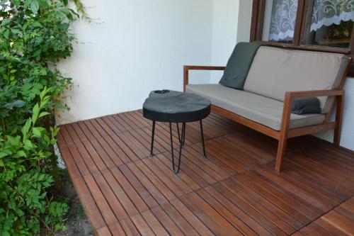 a chair and a table on a wooden deck at Magic Wood Guest House in Lidzbark Warmiński
