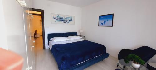 a bedroom with a blue bed and a chair at Apartments MYRJAM in Baška