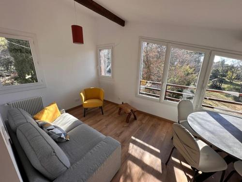 un salon avec un canapé et une table dans l'établissement Un appartement lumineux, à Aix-en-Provence