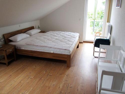 een slaapkamer met een groot bed met een houten vloer bij House Saga - Huus Asgard in Nieby