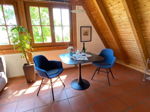 a table and chairs in a room with windows at Traumblick Rebenmeer in Gleisweiler