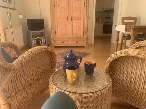 a table with a tea pot and two cups on it at Watthuus Kiebitzhörn Apartment in Horumersiel