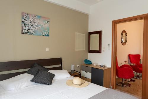 1 dormitorio con cama, escritorio y sillas rojas en Anna's house, en Rodas