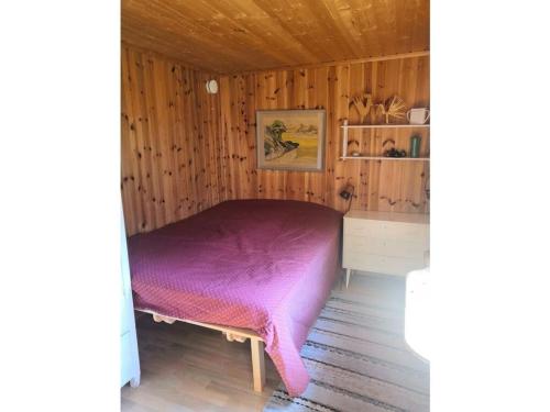 a bedroom with a purple bed in a wooden room at Pure relaxation in Sweden in Molkom