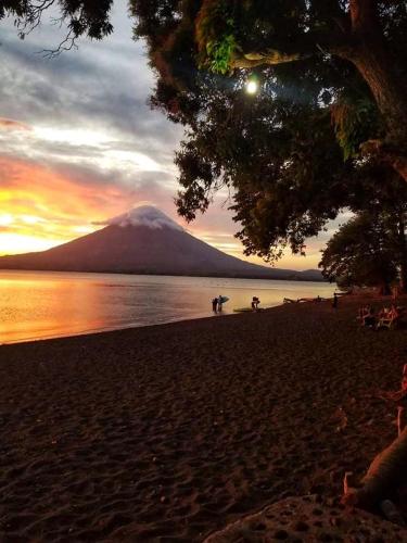 a mountain in the distance with a beach with a sunset at B&B, family run homestay, Hospedaje La Penita in Altagracia