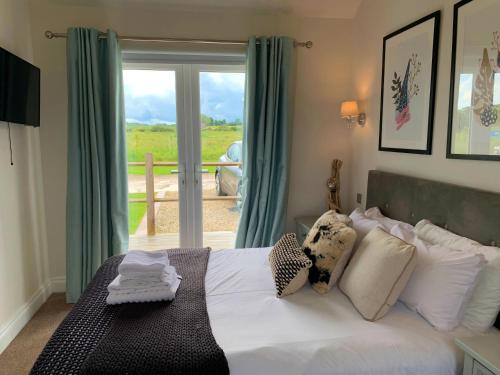 a bedroom with a bed and a large window at Seahorse Lodge at The Bay Filey, sleeps up to 6, and 2 dogs stay for free! in Filey