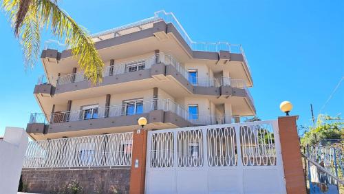 a building with a white fence in front of it at OLEANDRI 3 - Casa ETNA in Aci Castello