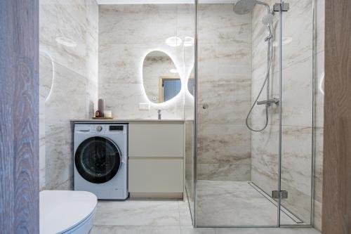 a bathroom with a washing machine and a shower at Vanagupės Perlas in Palanga