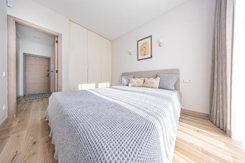 a white bedroom with a large bed in it at Vanagupės Perlas in Palanga
