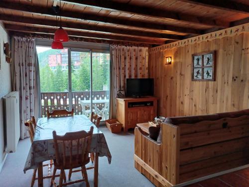 - un salon avec une table et une télévision dans l'établissement Le chambeyron praloup 1600, à Uvernet