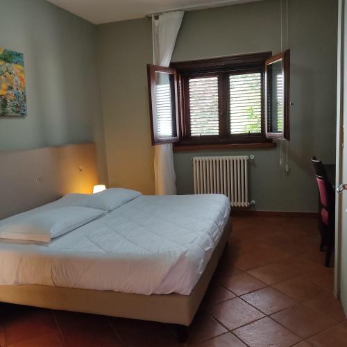 a bedroom with a bed and two windows at Maglioferro Residence in Corato