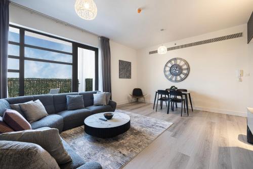 シャルジャにある2Bedroom Apartment - Uptown Al Zahia, Sharjah - Stone Houseのソファとテーブルのあるリビングルーム