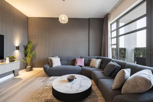 a living room with a couch and a table at 2Bedroom Apartment - Uptown Al Zahia, Sharjah - Stone House in Sharjah