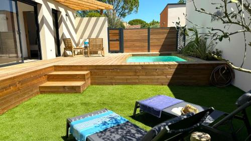 a backyard with a swimming pool and a deck with a patio at DAYA LODGE. in LʼIsle-sur-la-Sorgue