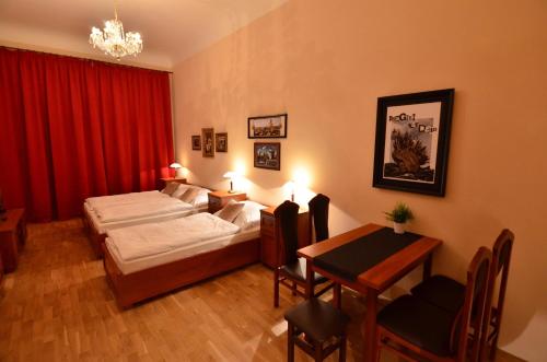 a bedroom with a bed, desk, chair and lamp at Pension Karlova in Prague