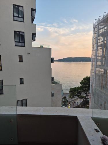 a view of the water from the balcony of a building at Rafailovici Beachfront Apartment 2 in Budva