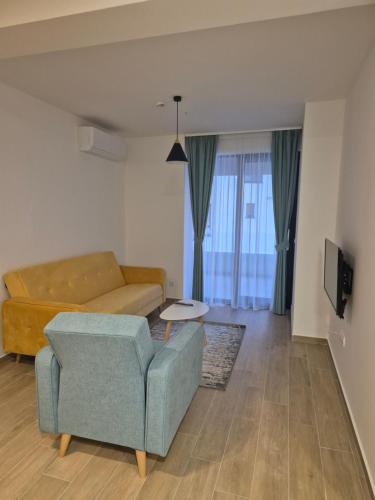 a living room with a couch and a chair at Rafailovici Beachfront Apartment 2 in Budva