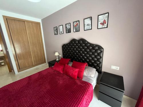 a bedroom with a large red bed with red pillows at Fantástico apartamento playa in Cala de Finestrat