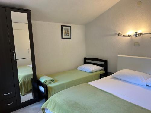 a hotel room with two beds and a mirror at Haus Karin in Lovran