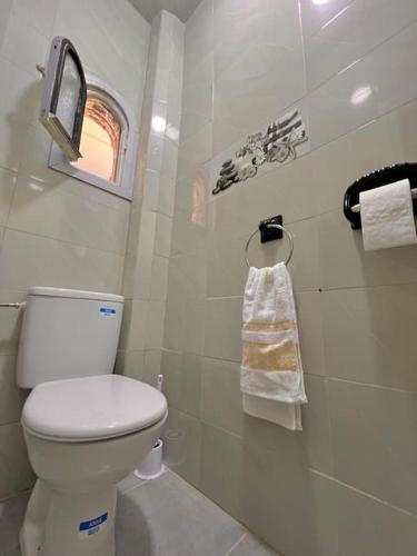 a bathroom with a white toilet and a window at An elegant apartment in Essaouira