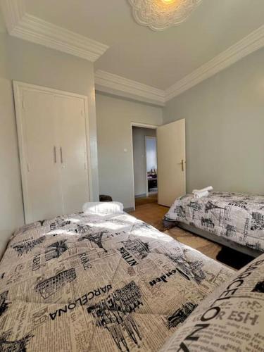 a bedroom with two beds and a chandelier at An elegant apartment in Essaouira