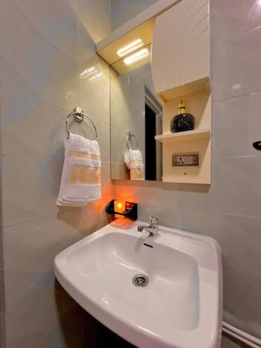 a bathroom with a white sink and a mirror at An elegant apartment in Essaouira
