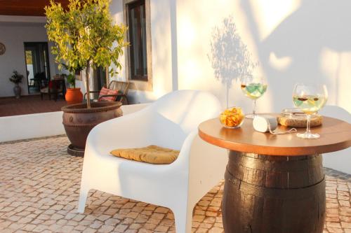 a table and chairs with wine glasses on a barrel at Monte do Couto in Albufeira