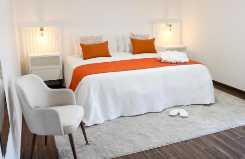 a bedroom with a large bed and a chair at Monte do Couto in Albufeira