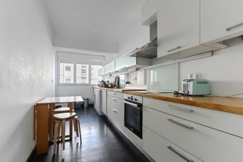 a kitchen with white cabinets and a wooden counter top at BFF - Beach Family and Friends in Carcavelos