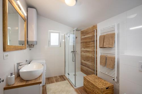 a white bathroom with a sink and a shower at Villa Mala Smišna Poolside Paradise by the Sea in Maslinica