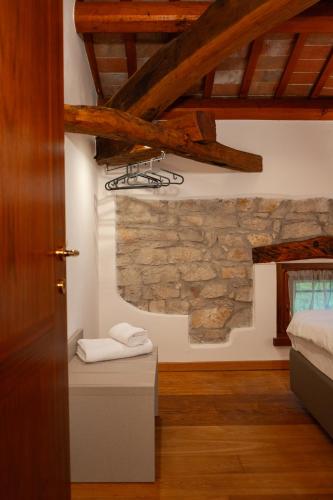 a bedroom with a stone wall and a bed at La Valle dei Laghi in Revine Lago