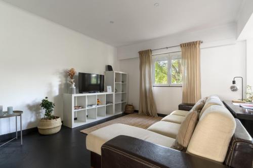 a living room with a couch and a tv at BFF - Beach Family and Friends in Carcavelos