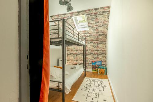 a room with a bunk bed and a brick wall at La Bulle Détente : Maison avec Jacuzzi et Sauna in Montrichard
