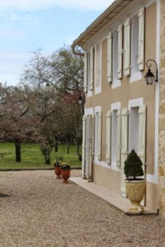 un bâtiment avec des plantes en pot sur son côté dans l'établissement Domaine du Lacarès, à Saint-Magne-de-Castillon