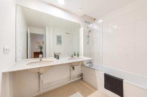 une salle de bain avec deux lavabos et un grand miroir dans l'établissement Montparnasse & Studio & Downtown, à Paris