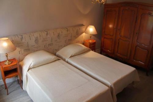 - une chambre avec 2 lits et 2 lampes sur les tables dans l'établissement Domaine du Lacarès, à Saint-Magne-de-Castillon