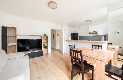 Il dispose d'une cuisine et d'un salon avec une table et des chaises en bois. dans l'établissement Montparnasse & Studio & Downtown, à Paris