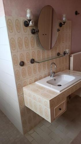 une salle de bain avec un lavabo et un miroir dans l'établissement Maison de campagne avec accès piscine - Linge non fourni, à Beaugas