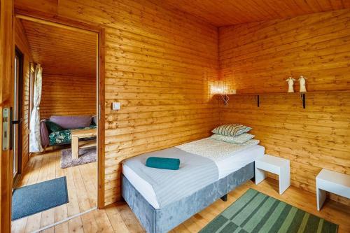 a bedroom with a bed in a wooden room at Domki nad Odrą Wały in Brzeg Dolny