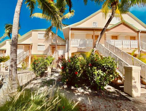 a house on the beach with palm trees at Cosy Maracuja, appartement calme à 2 min de la plage ! in Orient Bay