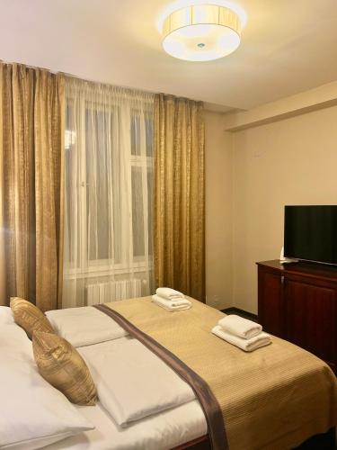 a bedroom with a bed with two towels on it at U Stare Pani - At the Old Lady Hotel in Prague