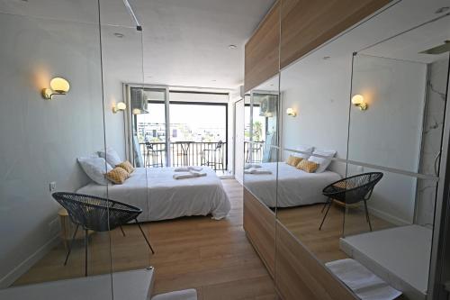 une chambre avec deux lits et un balcon dans l'établissement Studio B Heliopolis FGH, au Cap d'Agde