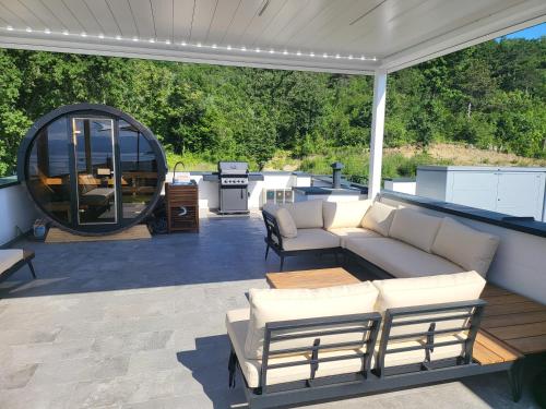 a patio with a couch and a table and a grill at Cassiopeia - Seaside Retreat in Omišalj