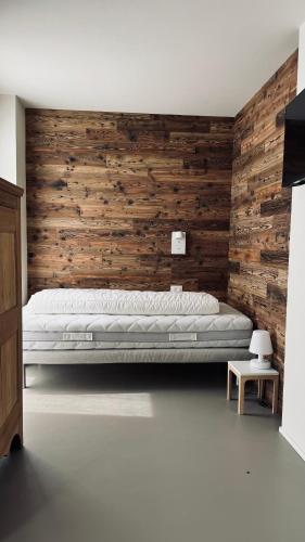 a bedroom with a bed and a wooden wall at Ca' De Sass in Pila
